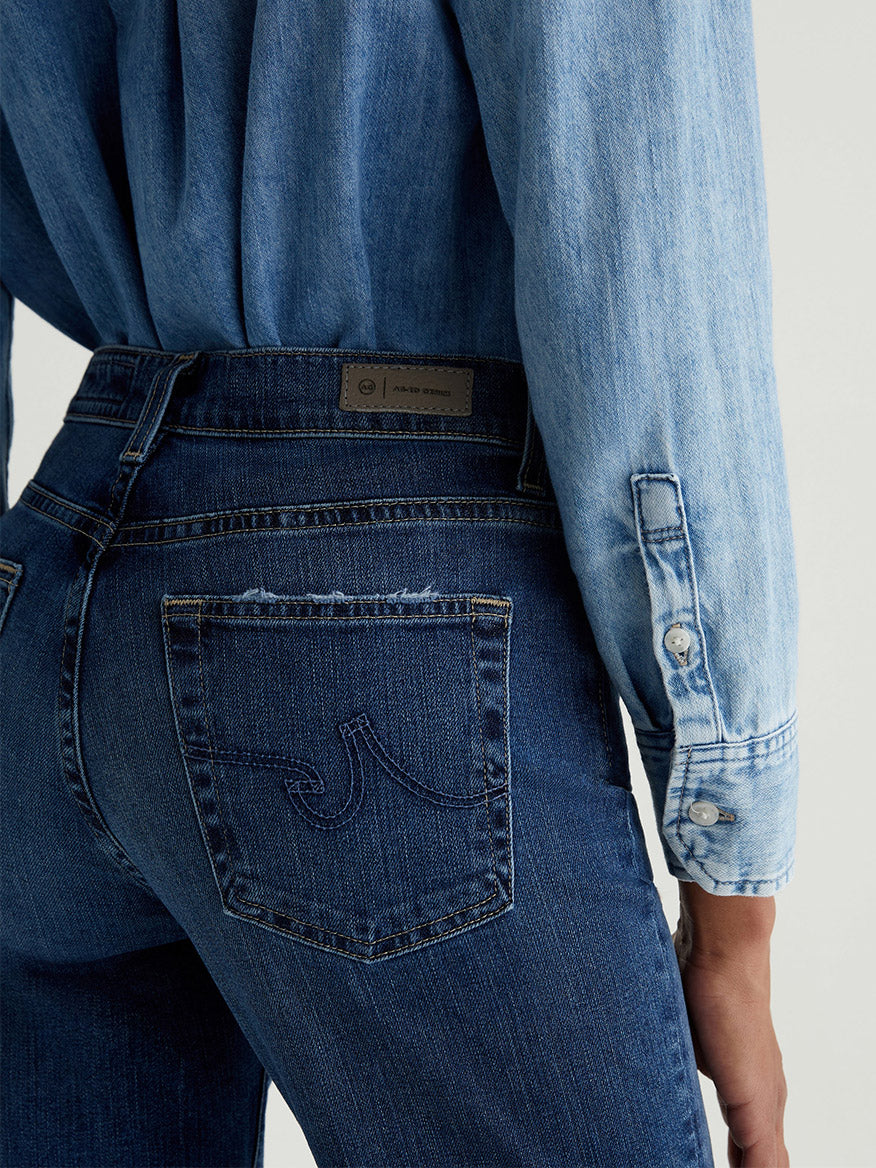 Person wearing the AG Jeans Brinley Crop in 7 Years La Jolla, a dark indigo vintage comfort stretch denim, shown from the back with visible pocket and branded waistband patch.