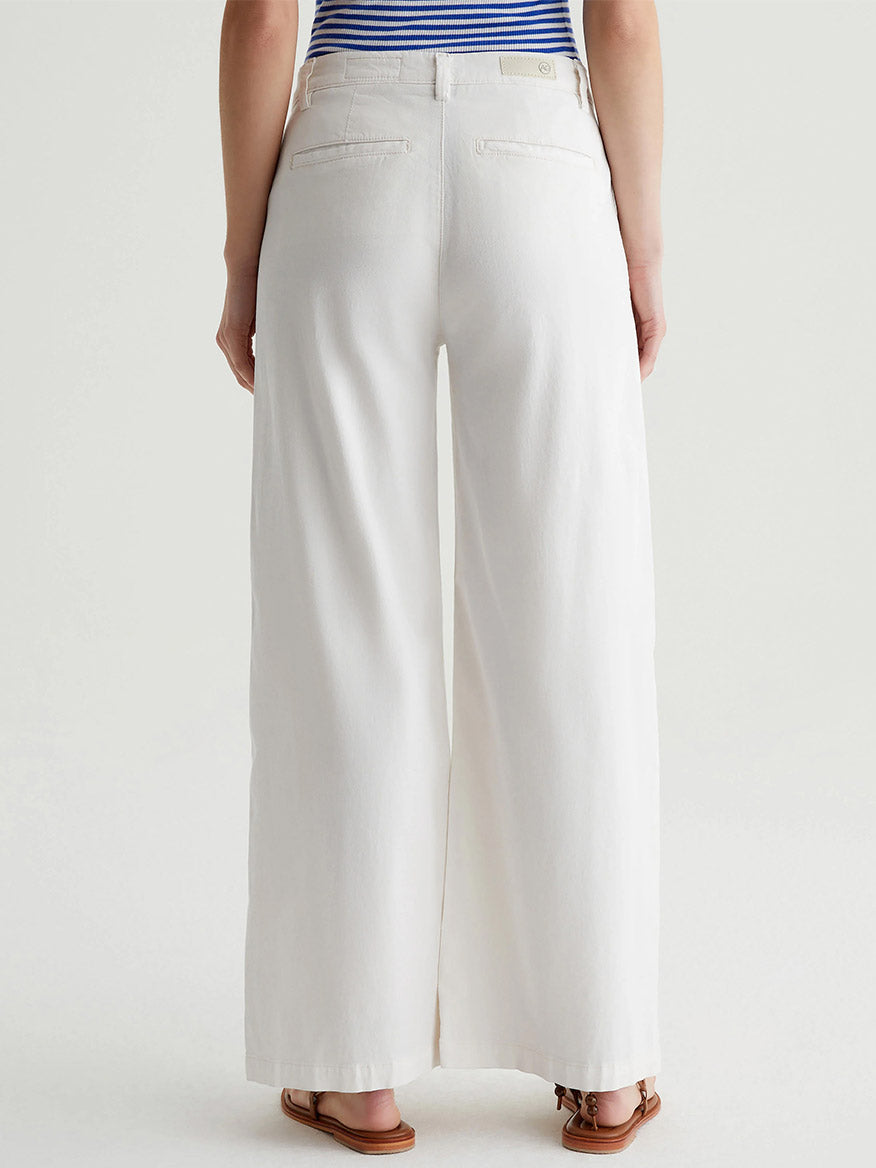 Individual wearing the AG Jeans Caden Wide-Leg Trousers in Powder, combined with a blue and white striped top, seen from behind.