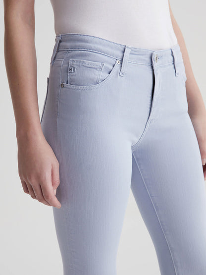 Close-up of a person wearing light blue AG Jeans Prima Cigarette Leg in Sulfur Blue Whisper skinny jeans.
