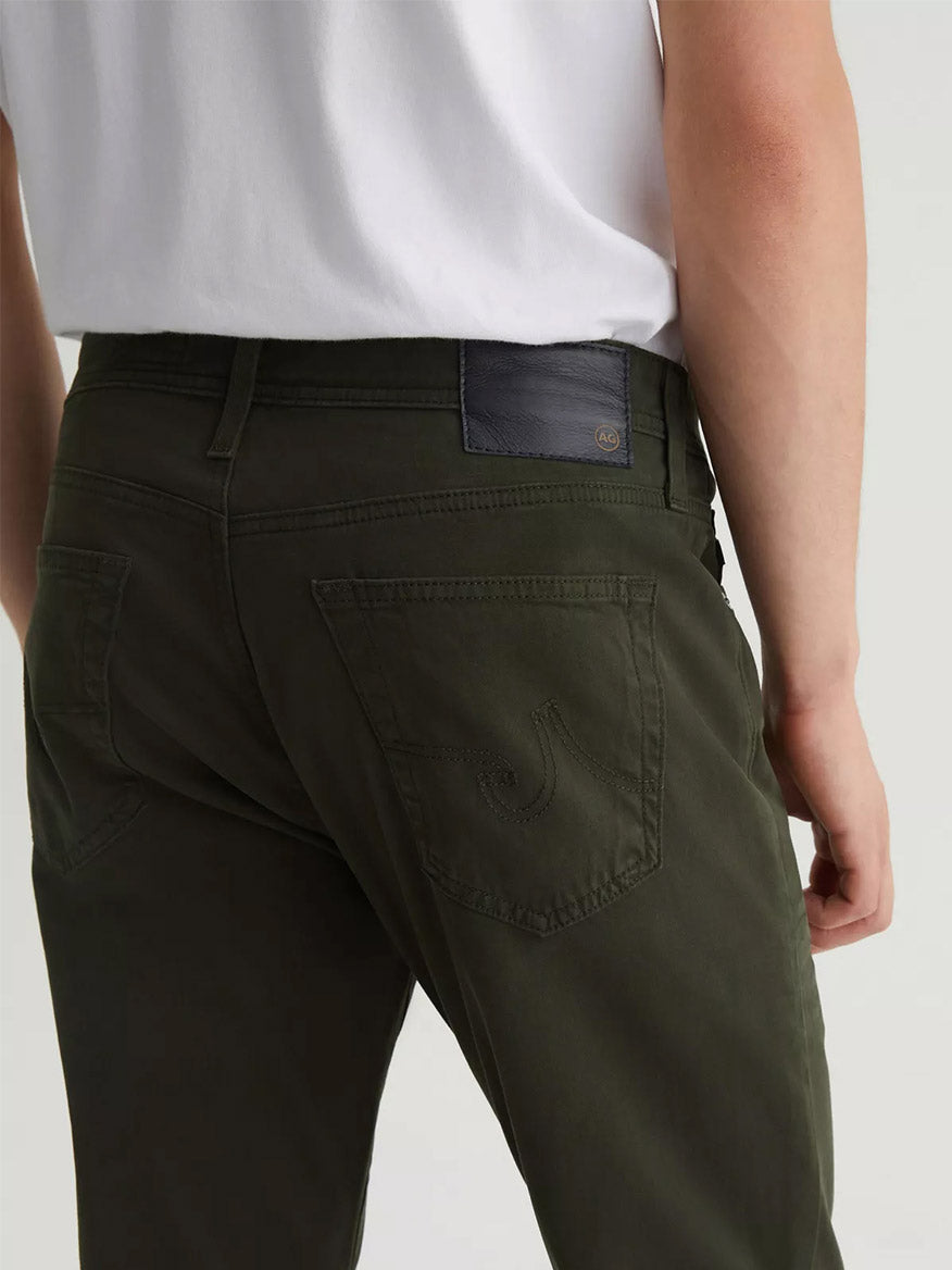 The back view of a man in AG Jeans Tellis in Forest Mist.