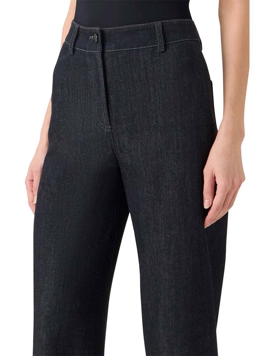 Someone wearing the Akris Punto Caia High-Rise Straight Leg in Black Denim, featuring a straight leg cut and visible white stitching.
