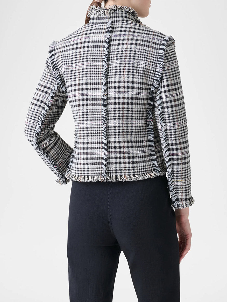 A person is seen from the back wearing the Akris Punto Check Fringe Hem Cropped Jacket in cream/black with frayed edges and a boxy silhouette, paired with dark pants.