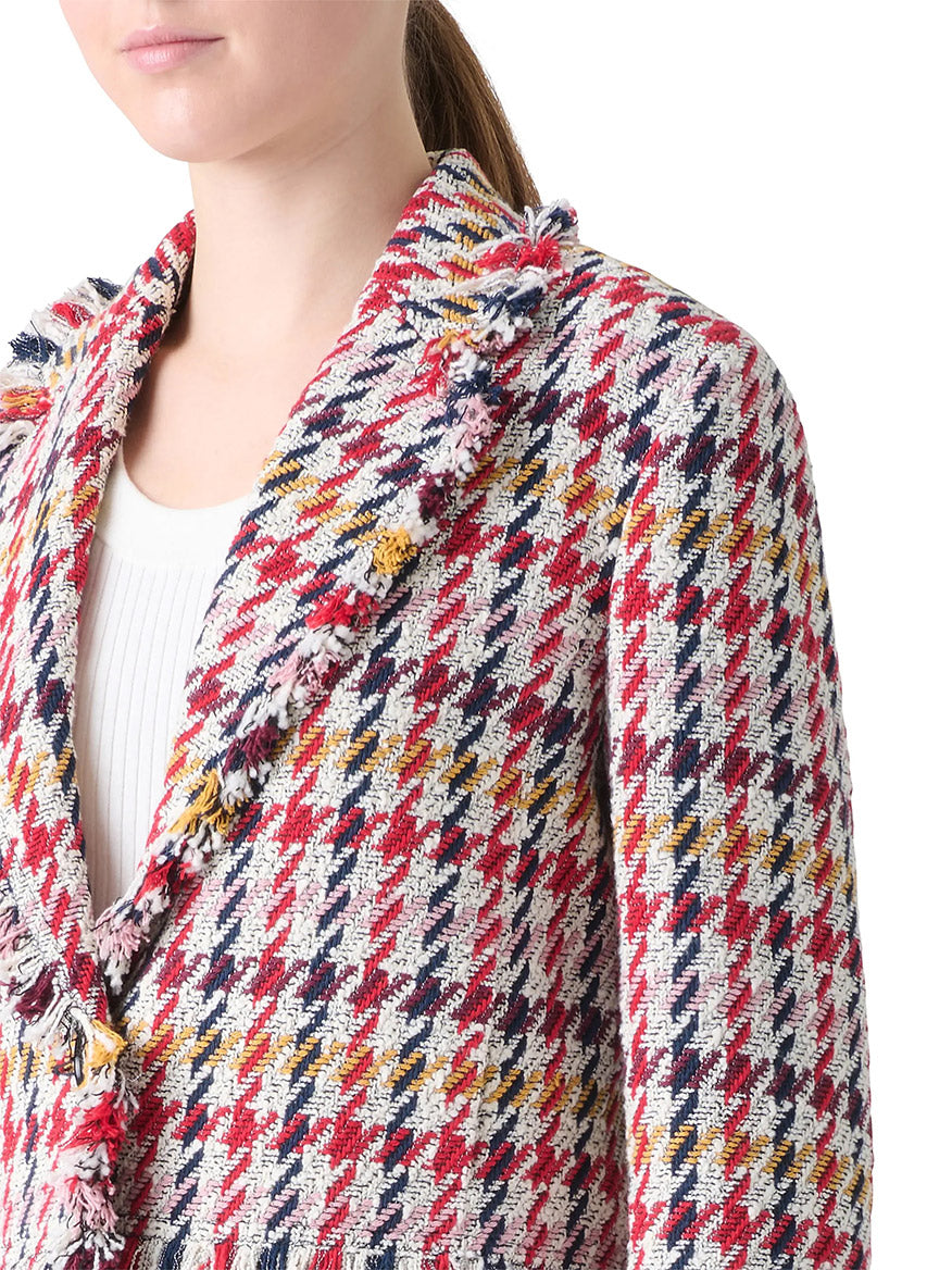 A person wearing the Akris Punto Houndstooth Tweed Fringe Trim Blazer in Cream Multi over a white ribbed top.