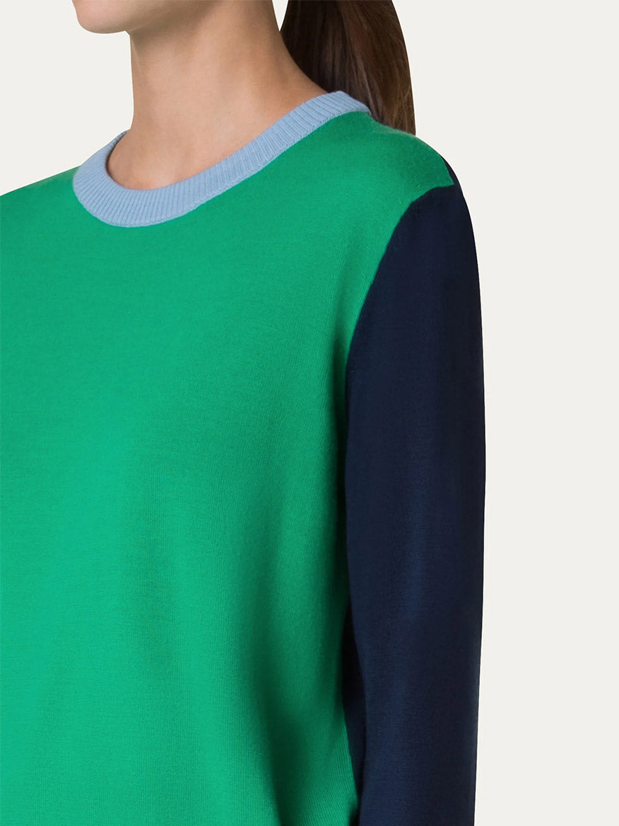 The person is wearing an Akris Punto Colorblock Merino Sweater in Sea Green/Navy/Sky, featuring a relaxed fit with a blue collar and navy sleeves, viewed from the side.