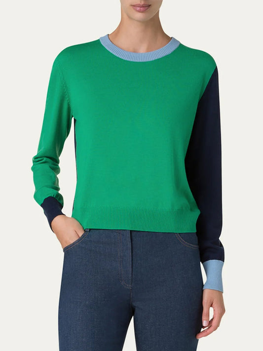 The person is in a relaxed fit, wearing an Akris Punto Colorblock Merino Sweater in Sea Green/Navy/Sky, paired with dark jeans.