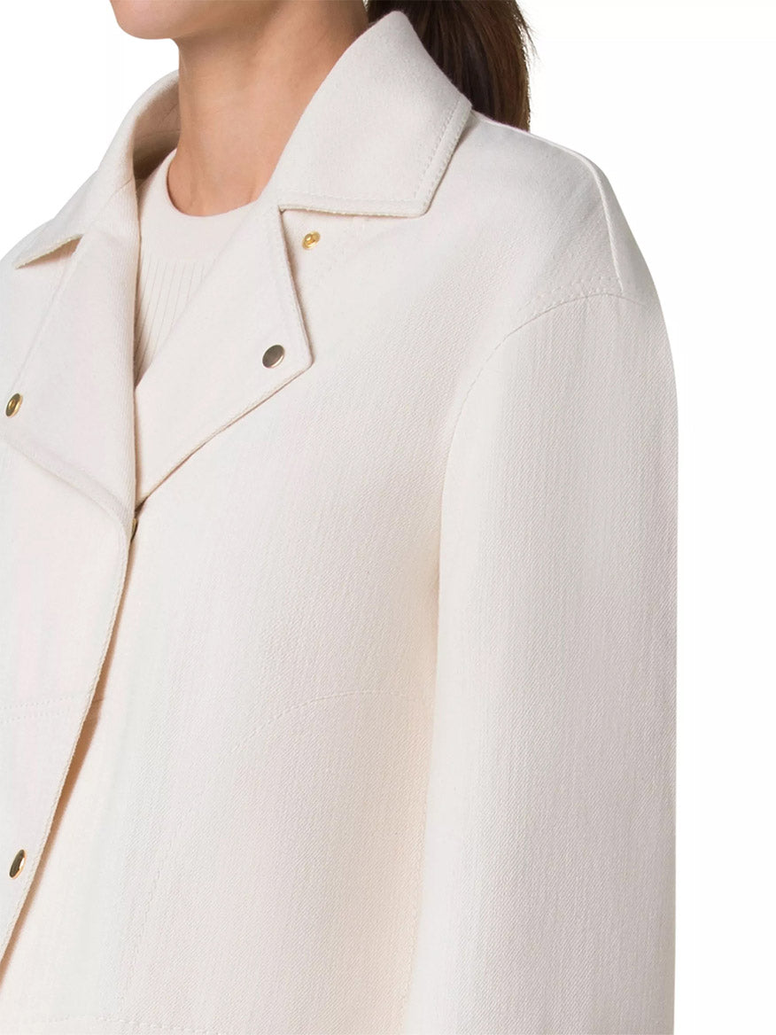 Someone is wearing an Akris Punto Asymmetrical Cotton Blend Biker Jacket in Cashew with gold snap buttons and an asymmetric snap closure, layered over a matching shirt.