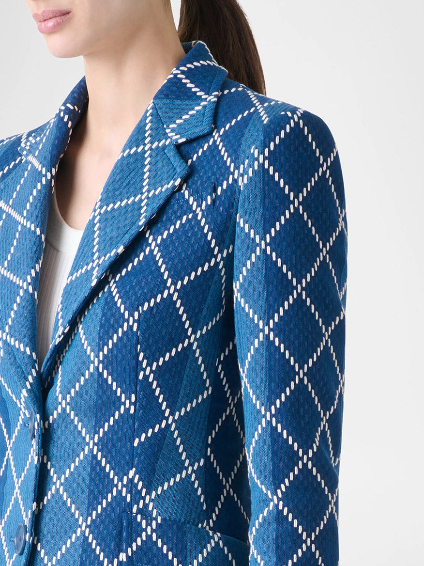 A person wearing the Akris Punto Diamond Cotton Jacquard Fitted Blazer in Medium Blue Multi over a white top, shown from shoulders to mid-torso.