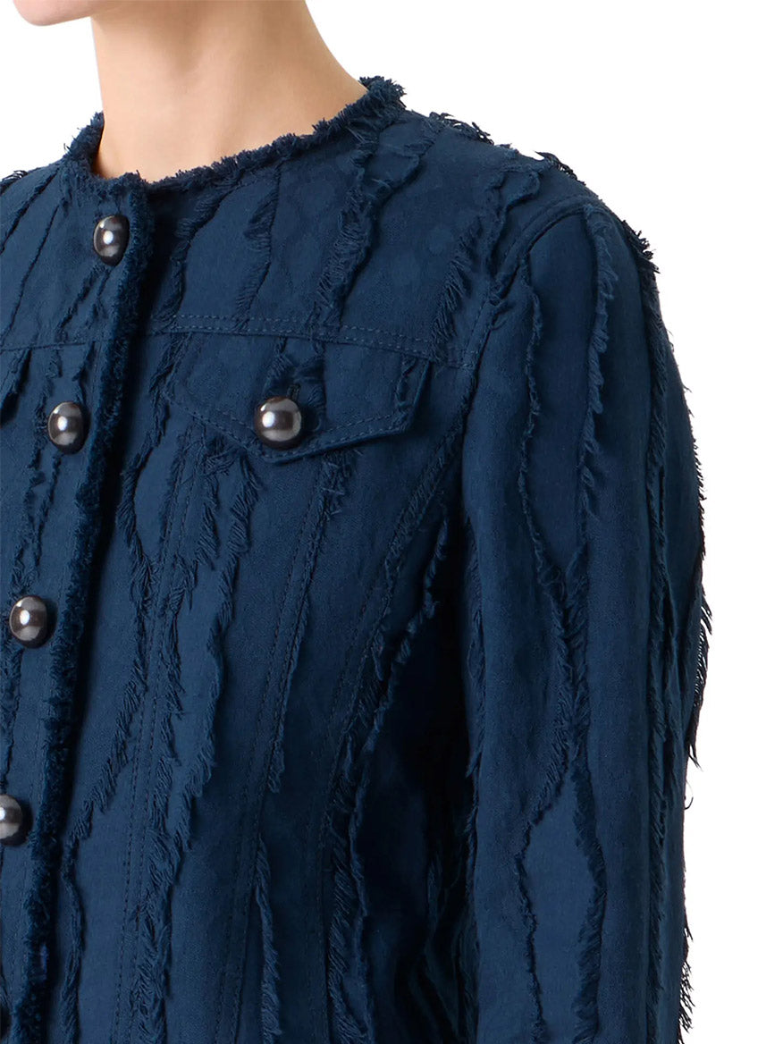 A person wearing the Akris Punto Fringed Wave Jacquard Jacket in Dark Blue, featuring frayed vertical stripes and large round buttons, shown from the shoulders down.