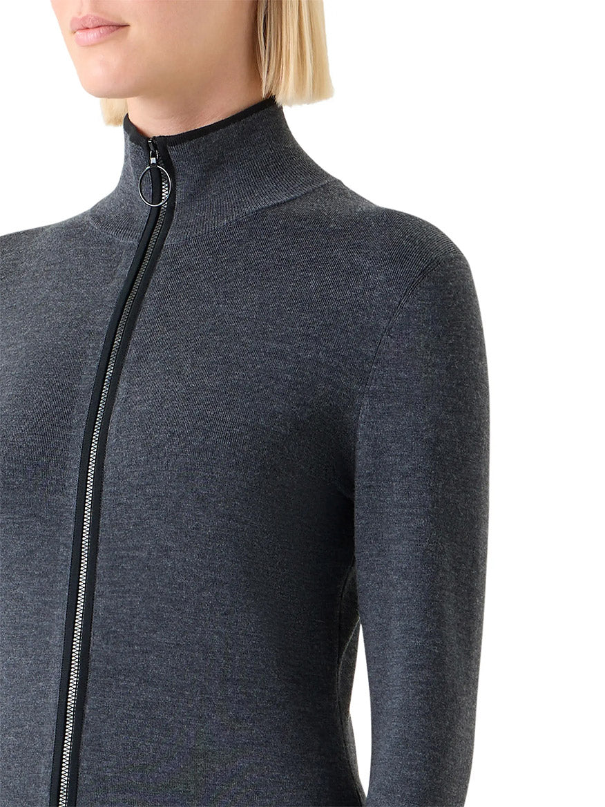 A person with short blonde hair wears a fitted, long-sleeve Akris Punto Virgin Wool Knit Zip Cardigan in Charcoal/Black.