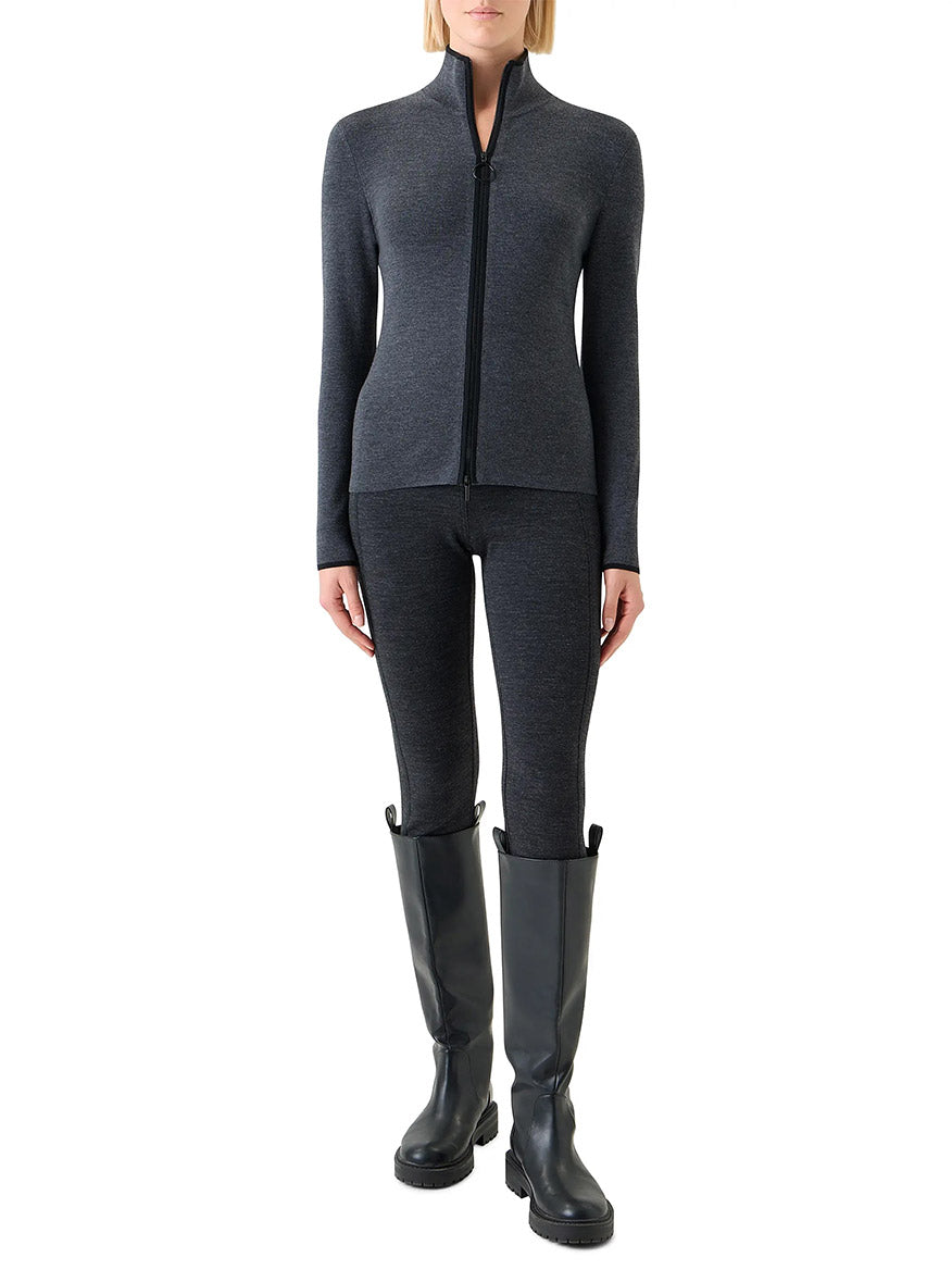 A person wears the Akris Punto Virgin Wool Knit Zip Cardigan in Charcoal/Black with matching leggings and black knee-high boots, standing against a white background.