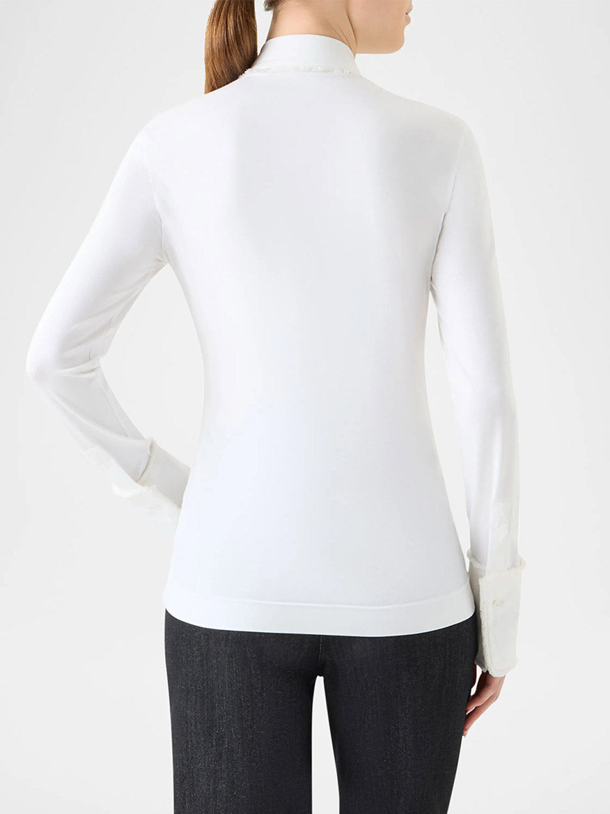 A person with a ponytail is shown from the back, wearing a fitted cream Akris Punto Mixed Media Fringed Button-Down Blouse and dark pants against a plain background.