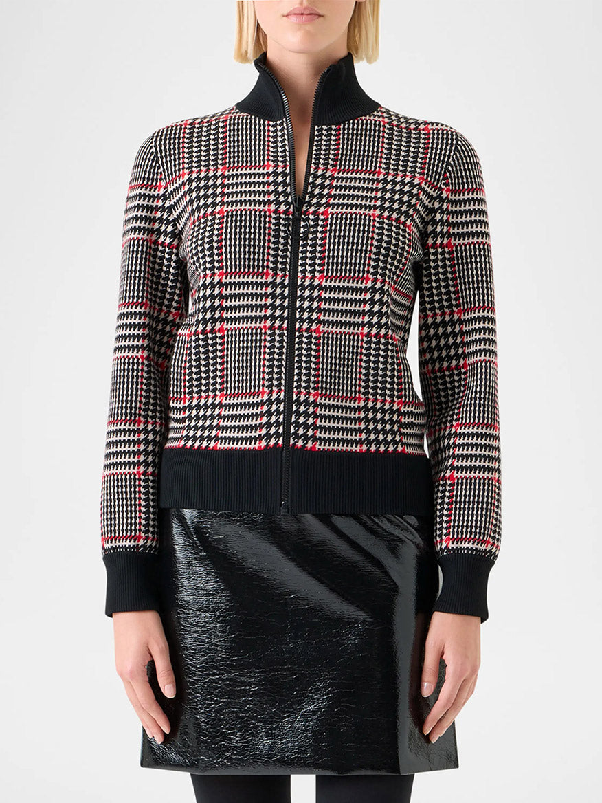 A woman wears the Akris Punto Mock Neck Plaid Cardigan in Black/Cream/Vermillion with a black vinyl skirt, photographed against a plain background.