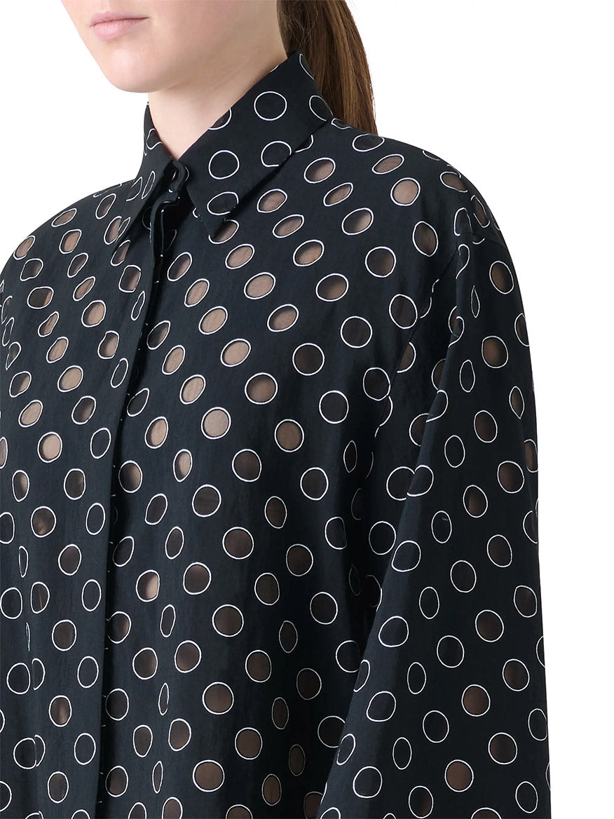 A person wearing the Akris Punto Boxy Polka Dot Organzino Blouse in Black/Cream, featuring sheer fabric with transparent polka dots.