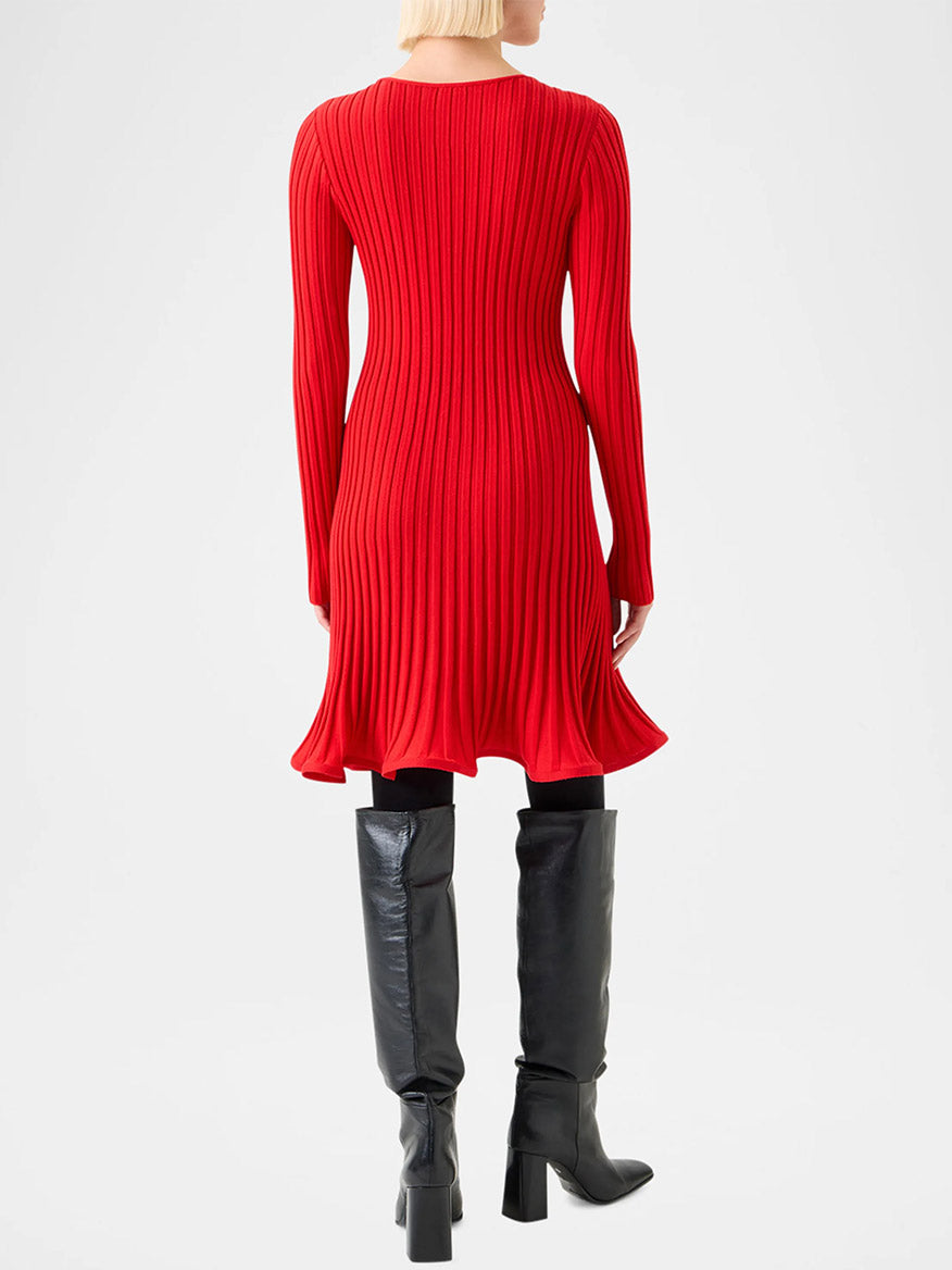 A person with short blonde hair is shown from the back, wearing the Akris Punto Reverse Rib Fit & Flare Mini Dress in Vermillion and black knee-high boots.