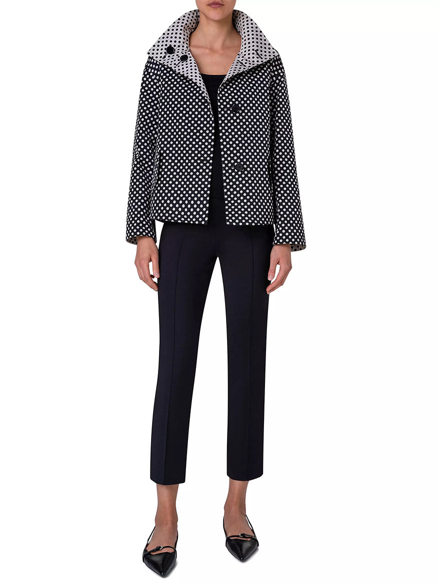 A person wears the Akris Punto Reversible Polka Dot Jacket in Black/Cream, featuring a cropped, boxy silhouette, paired with a black shirt, black cropped pants, and black pointed shoes against a plain background.
