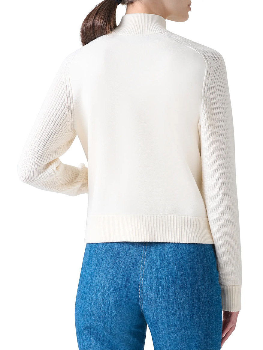 A person is shown from the back wearing blue jeans with zip pockets and the Akris Punto Rib-Knit Wool Zip Cardigan in Cream.