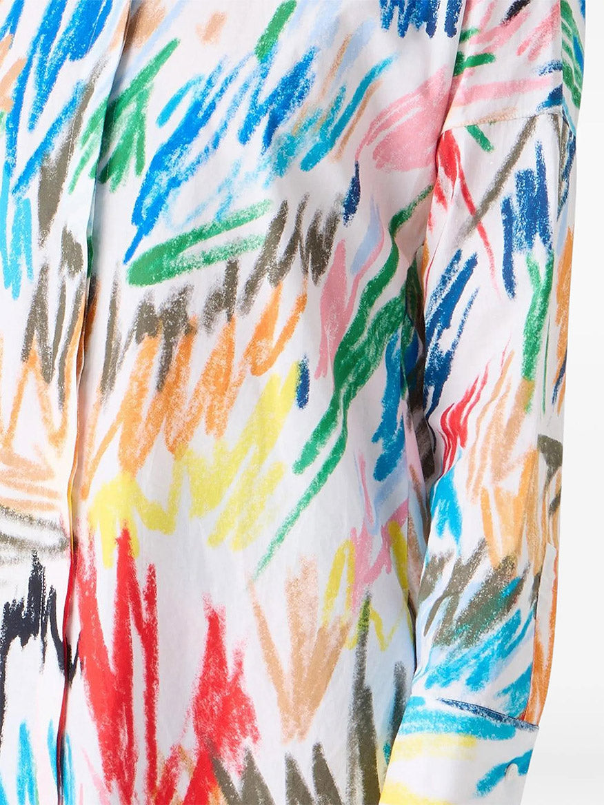 A close-up of the Akris Punto Scribble Print Tunic Blouse in Cream Multi, featuring a vibrant abstract brushstroke pattern in blue, green, red, pink, orange, yellow, and brown.