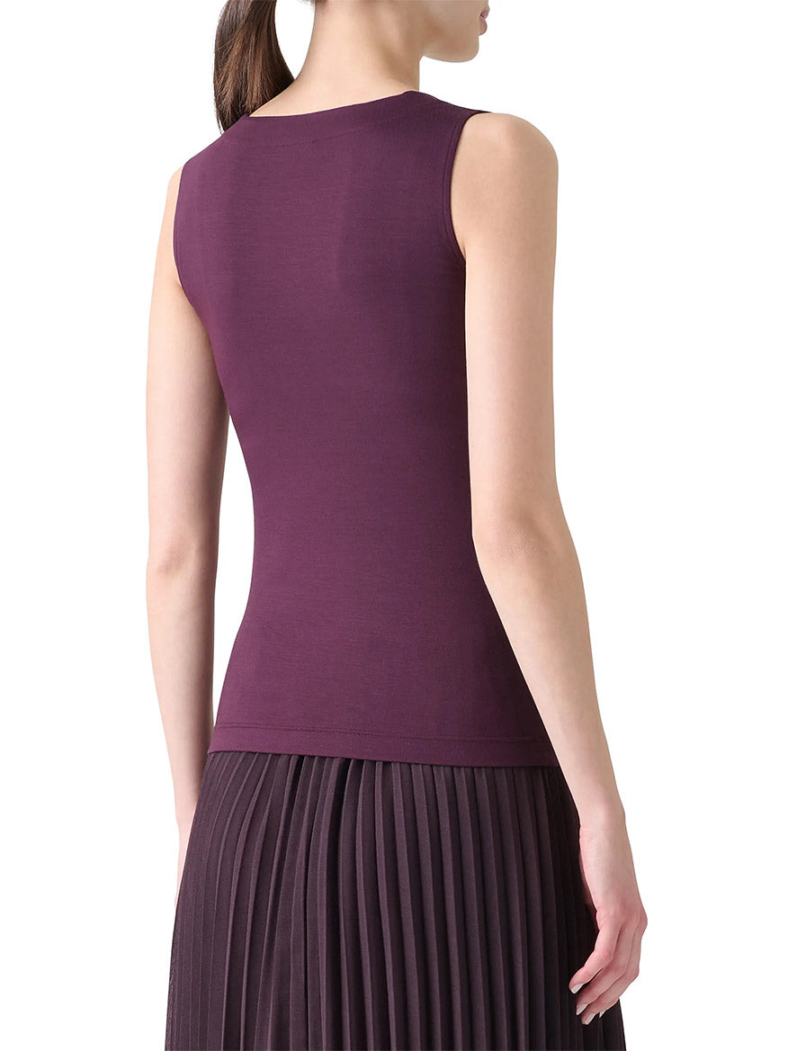 A woman is shown from the back wearing the Akris Punto Square-Neck Jersey Tank Top in Blackberry and a pleated skirt.