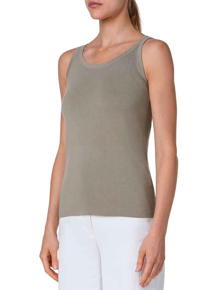 A woman wearing an Akris Punto Scoop Neck Cotton Tank Top in Sage and white pants by fashion house Akris Punto.