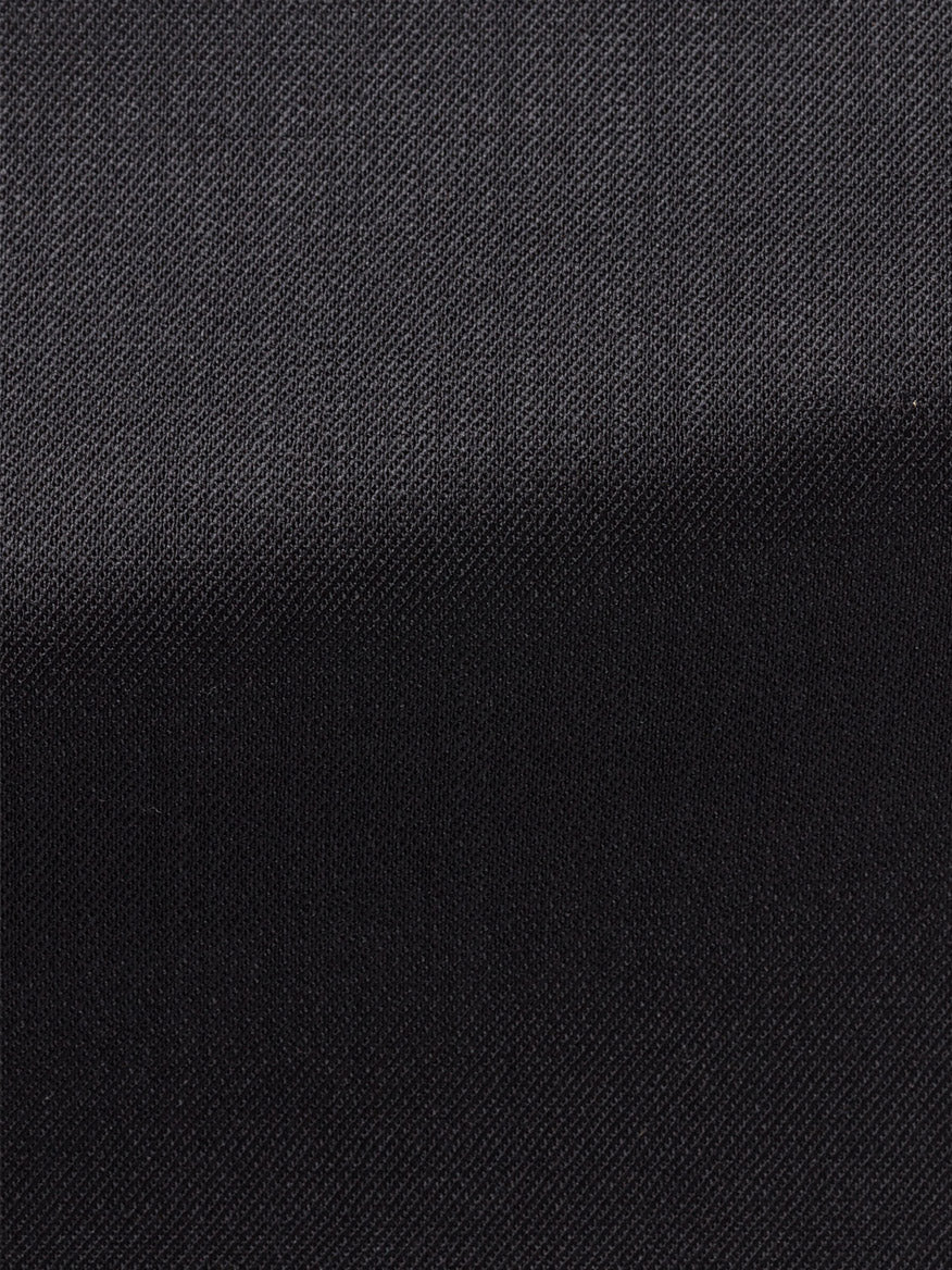 Close-up of Atelier Munro Black Twill 4-Season Wool Stretch Suit fabric, showcasing fine woven texture, diagonal fold, and subtle light reflection.