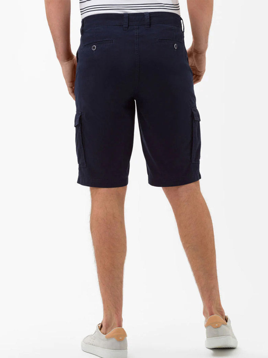 Man standing in Brax Brazil Cargo Shorts in Ocean and white sneakers.