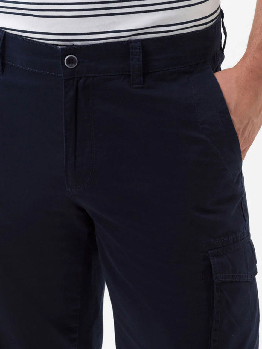 Close-up of a person wearing Brax Brazil Cargo Shorts in Ocean with a white and navy striped shirt tucked in.