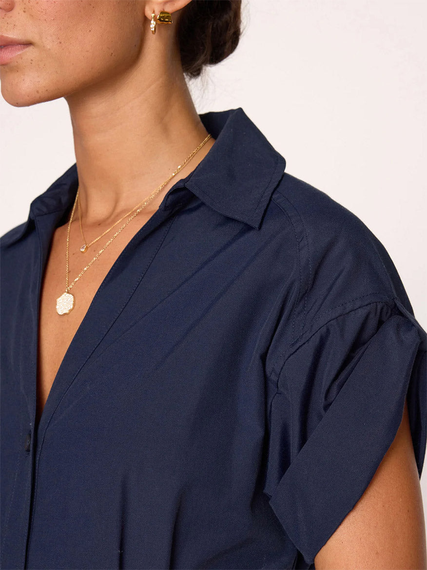 Close-up of a woman wearing a Brochu Walker Fia Belted Dress in Navy and layered necklaces, focusing on the jewelry and collar detail.