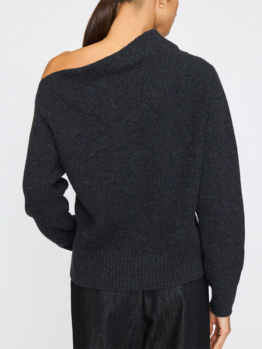 A person with long hair in a low ponytail wears the Brochu Walker Hart Off-Shoulder Sweater in Dark Charcoal and dark pants, shown from the back.