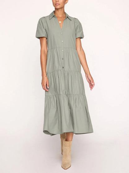 A person wearing a Brochu Walker Havana Dress in Agave with short sleeves, paired with beige ankle boots. Only the body from neck to feet is visible.