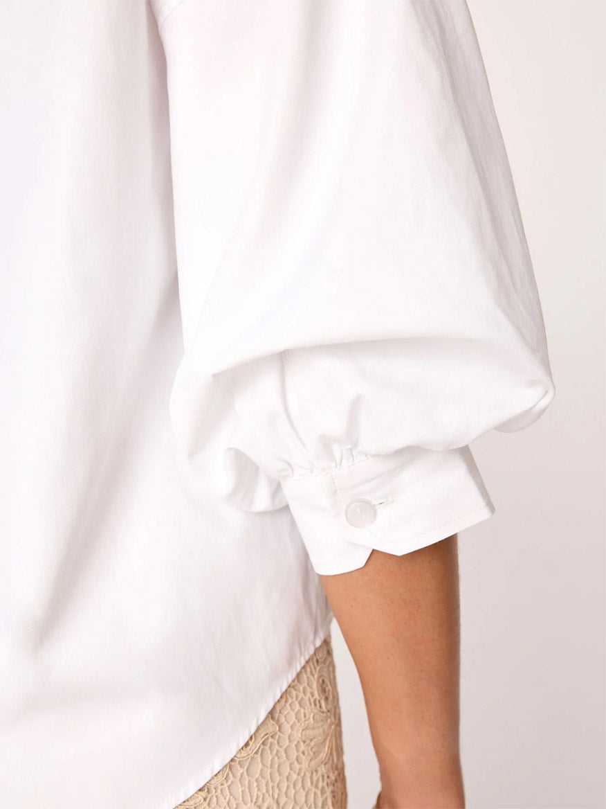 Close-up of a person's side with a focus on the rolled-up sleeve of the Brochu Walker Kate Shirt in Salt White, displaying an effortless sensuality.