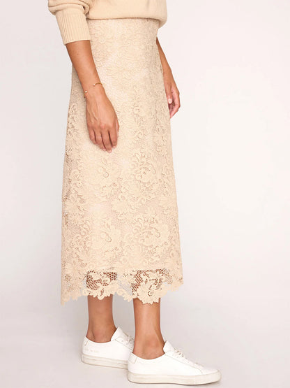 Woman wearing a Brochu Walker Mara Lace Skirt in Buff with a scalloped hem and white sneakers.