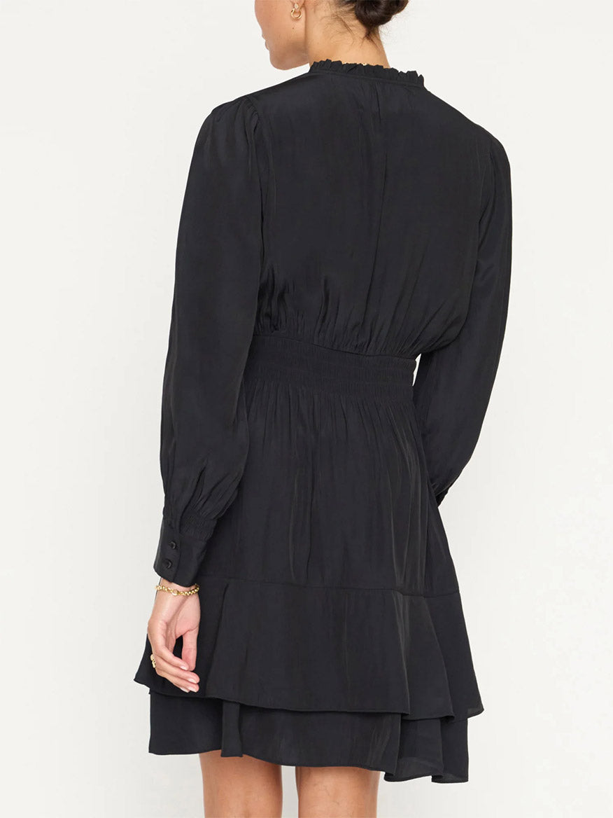 Woman from behind wearing a Japanese satin, black long-sleeve Brochu Walker Olivia Smocked Dress with ruffled tiers and an elastic waist.