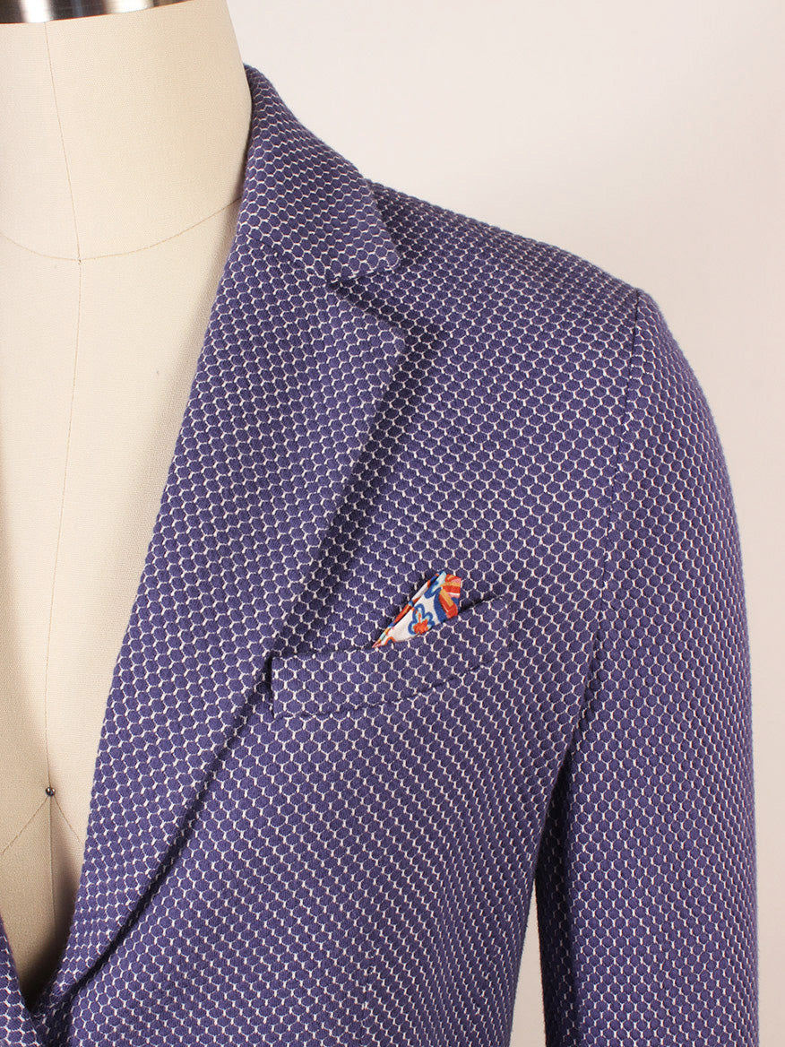 A close-up of a mannequin wearing the Circolo 1901 2-Button Slim Honeycomb Jacket in Space Cobalt, featuring notch lapels, a white pattern, and a colorful pocket square in the chest pocket.