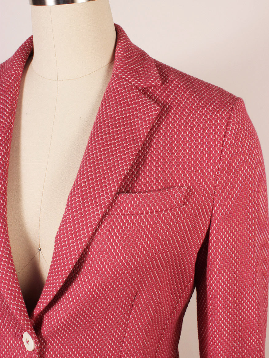 A close-up of a mannequin wearing the Circolo 1901 2-Button Slim Honeycomb Jacket in textured magenta with a white geometric pattern, notch lapels, and two white buttons.