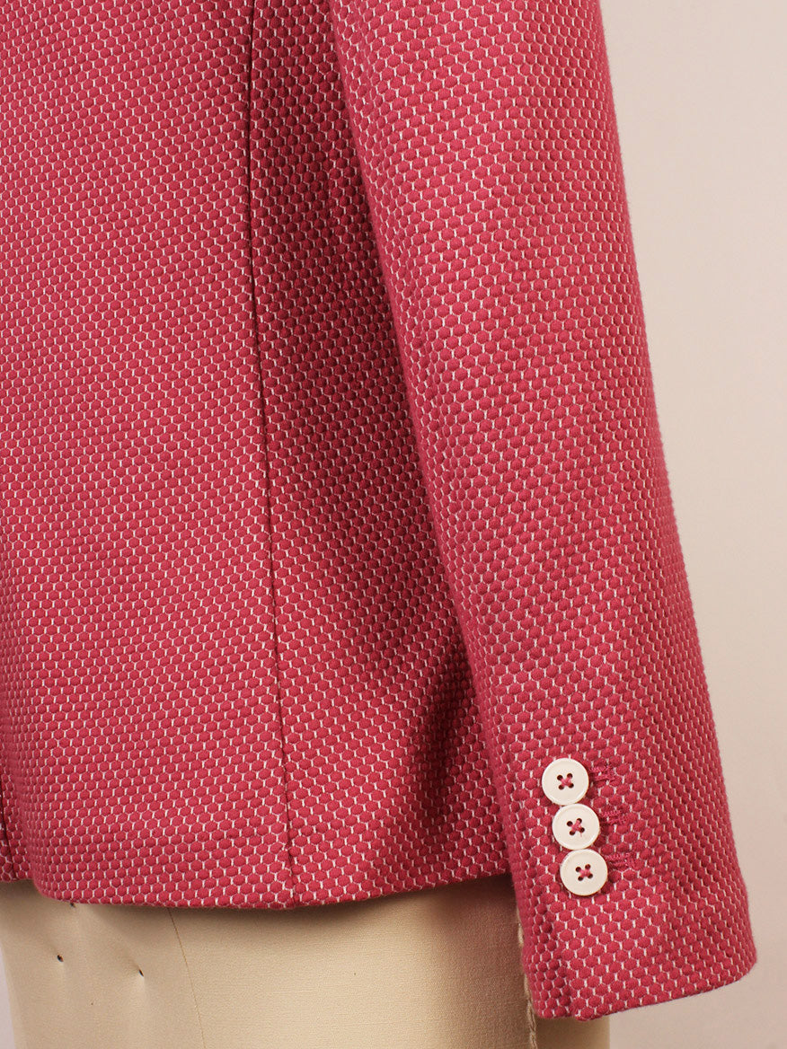 A close-up of the Circolo 1901 2-Button Slim Honeycomb Jacket in Magenta, featuring notch lapels and three white buttons on the cuff, displayed on a mannequin.