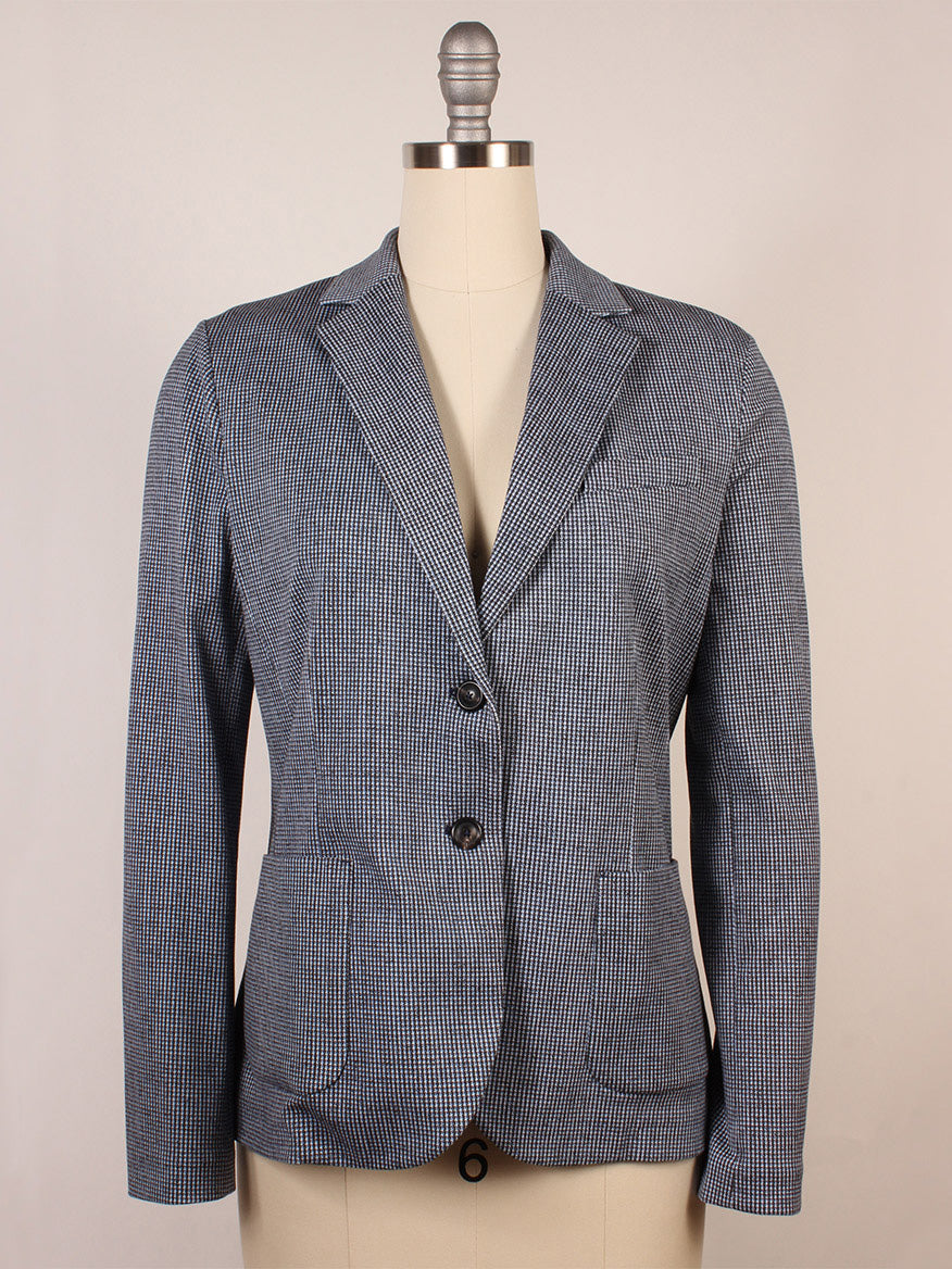 The Circolo 1901 Slim Fit Mini Houndstooth Jacket in Blue features a tailored silhouette, blue and white mini houndstooth pattern, notch lapels, and two buttons, shown on a dress form against a plain background.