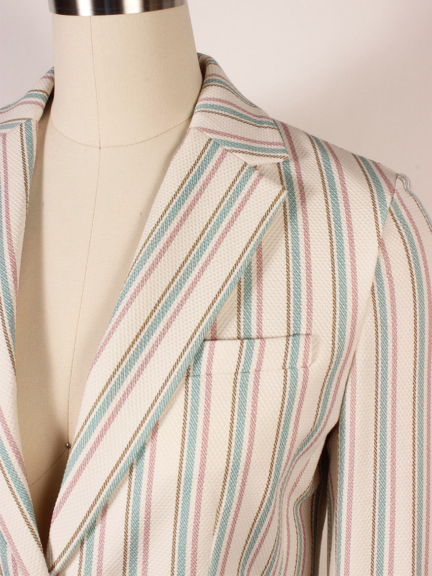 Close-up of the Circolo 1901 1-Button Slim Stripe Jacket in Laguna—beige with light blue, pink, and brown vertical stripes, notch lapels, and jetted pockets—displayed on a dress form.