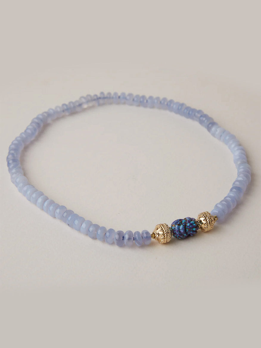 The Clara Williams Chalcedony Rondelle Mini Necklace features light blue round beads with three central accents: a Blue Chalcedony rondelle stone and two 14K yellow gold beads.