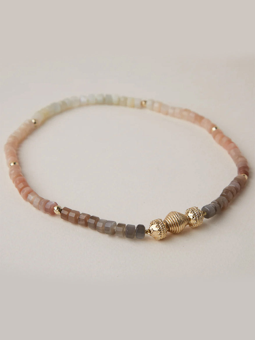 The Clara Williams Gold Lantern Mini Centerpiece is a beaded bracelet with square pastel pink, beige, and taupe beads, accented by a 14K gold-plated lantern bead at the center and small gold spacer beads.