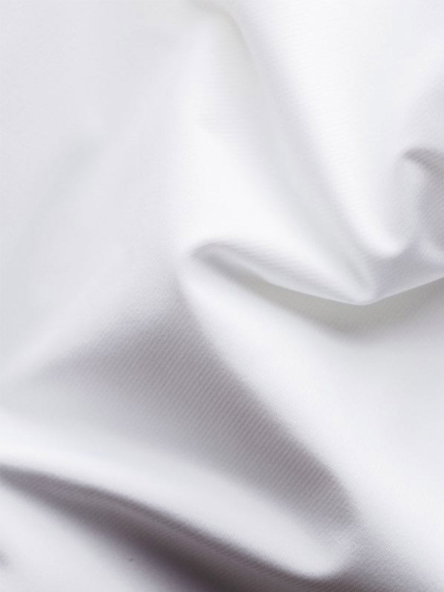 Close-up of the Eton Slim Fit White Four-Way Stretch Shirt fabric, showing soft texture, refined look, and subtle shadows in its white folds and creases.