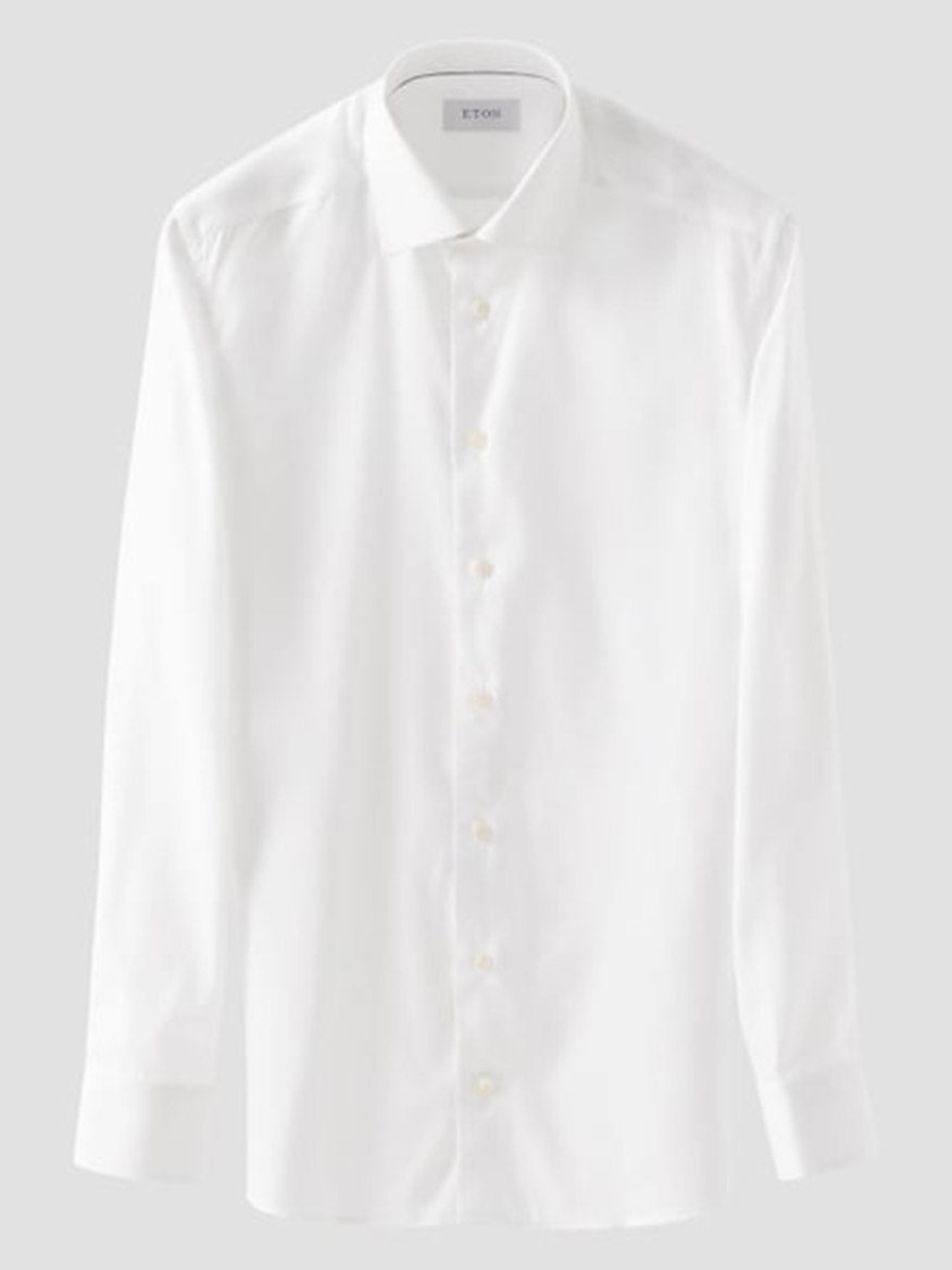 The Eton Contemporary Fit Semi Solid Dress Shirt in White features a collar, button front, and buttoned cuffs, displayed on a light gray background.