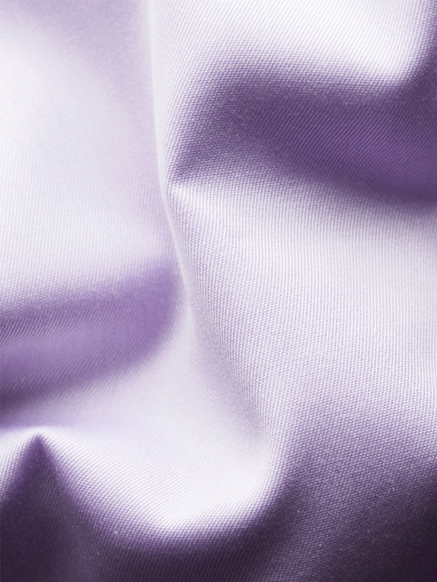 Close-up of smooth, light purple satin fabric with folds and soft shadows, evoking the luxurious feel of the Eton Contemporary Fit Solid Signature Twill Dress Shirt in Mid Purple.