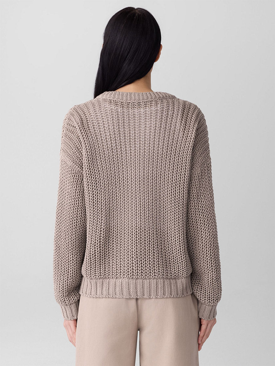 Person with long dark hair wears the Eileen Fisher Peruvian Organic Cotton Cord Crew Neck Top in Wheat, featuring a boxy fit, paired with tan pants and shown from the back against a plain light background.