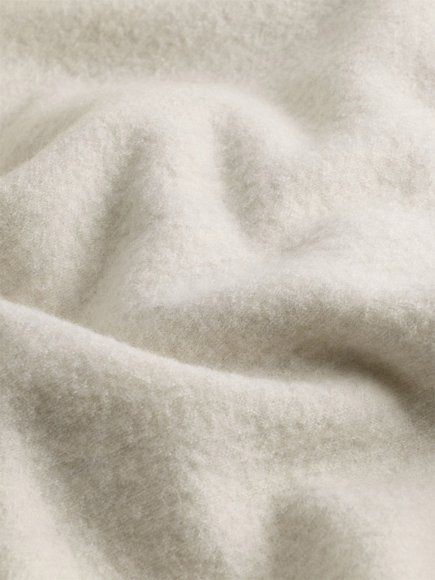 Close-up of soft folds of off-white felted fabric from the Eileen Fisher Fine Felted Wool Turtleneck Top in Regenerative Wool in Plaster.