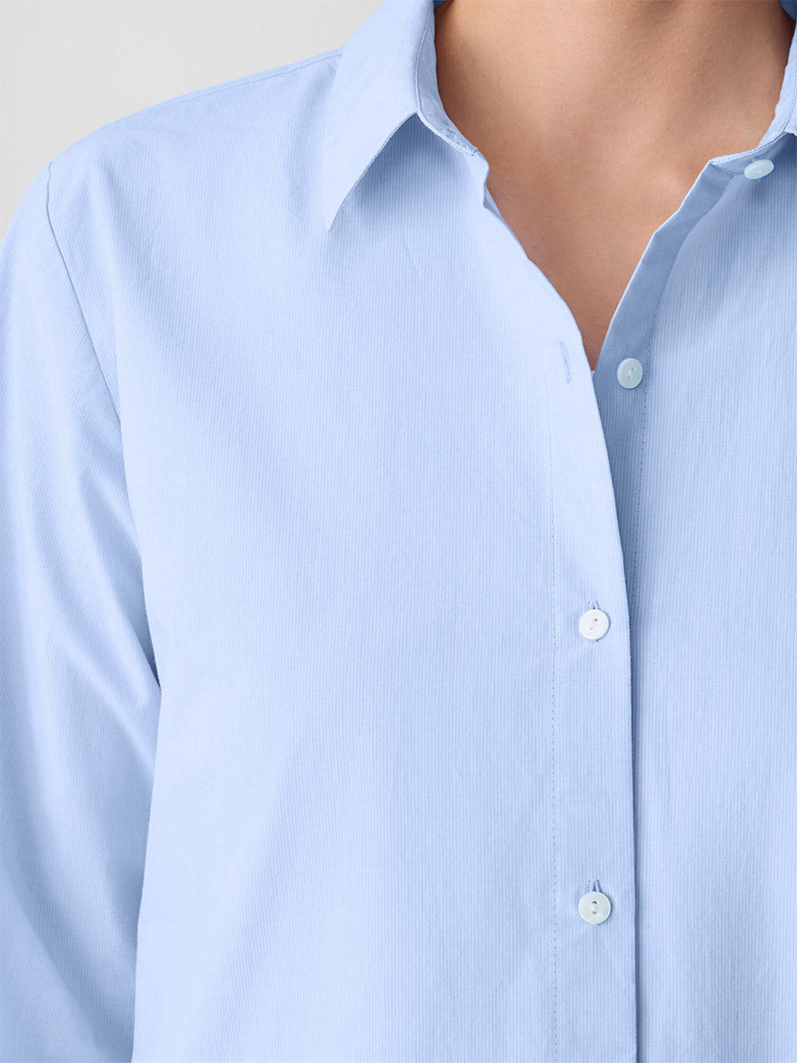 A person wearing the Eileen Fisher Striped Poplin Classic Collar Shirt in Myrtle, shown from the shoulders to the chest.