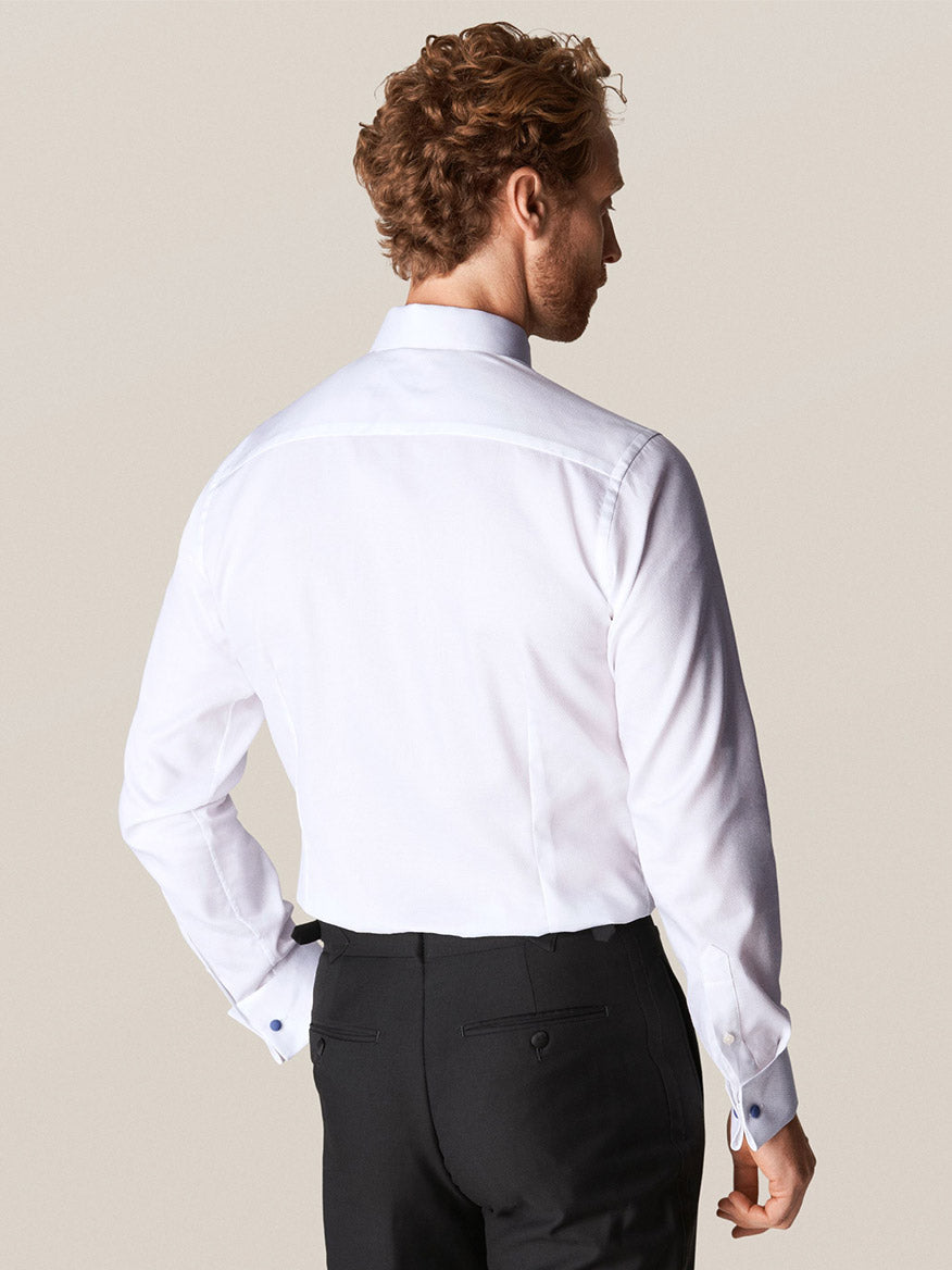 A man with curly hair is seen from behind, wearing an Eton White Dobby Formal Shirt and dark trousers.