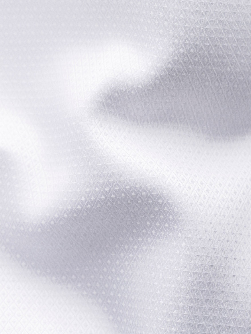 Close-up of an Eton White Dobby Formal Shirt made from dobby fabric, featuring a textured, diamond pattern surface with subtle shadows formed by folds.