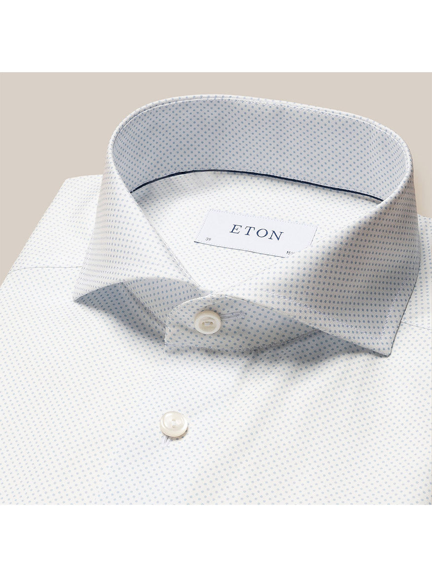 A folded white poplin shirt with a polka dot print, featuring the brand label "Eton Light Blue Polka Dot Print Dress Shirt" on the collar.