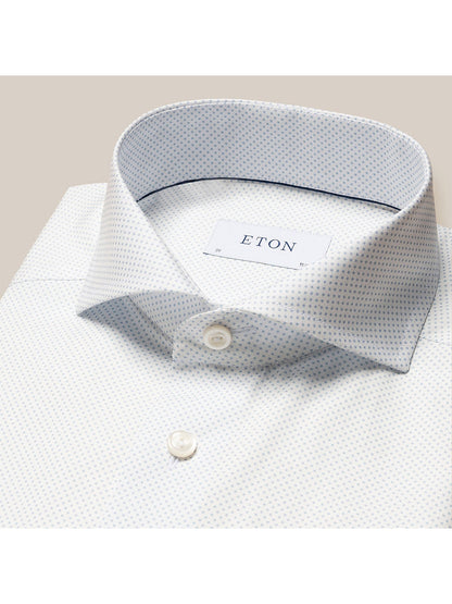 A folded white poplin shirt with a polka dot print, featuring the brand label "Eton Light Blue Polka Dot Print Dress Shirt" on the collar.