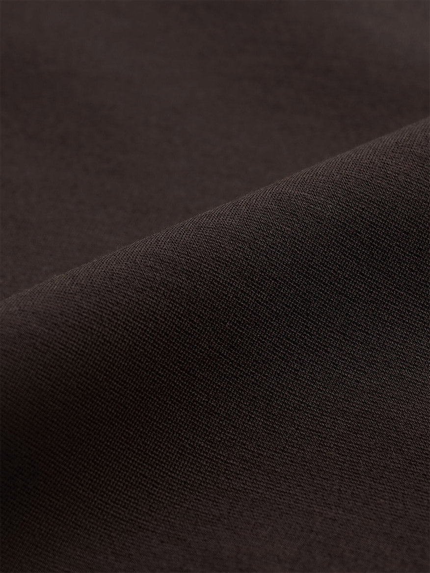Close-up of folded dark brown knit fabric in the Eileen Fisher Extra-Fine Ponte Kick Pant in Coffee.